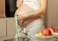pregnant-woman-eating-apple-measuring-her-belly_23-2148352151-kopi